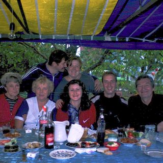 Group gathering outdoors at a festive table.