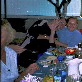 Group celebrating outdoors at a dinner table.