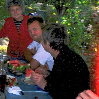Group celebrating outdoors at a dinner table.