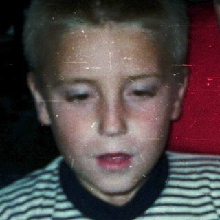 Boy blowing out birthday candles on cake.