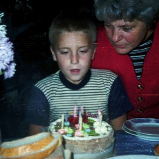 Boy blowing out birthday candles on cake.