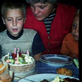 Boy blowing out birthday candles on cake.