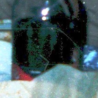 Three people gathered indoors, eating and drinking.