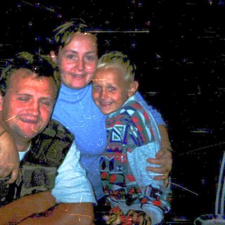 Family enjoying wet outdoor nighttime activity together.