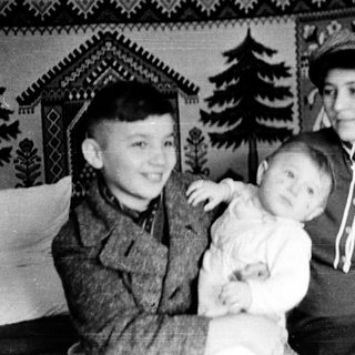 Family portrait with two adults and a child indoors.