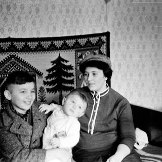 Family portrait with two adults and a child indoors.