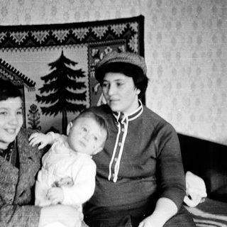 Family portrait with two adults and a child indoors.