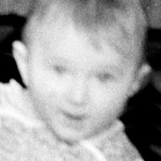Young child in winter clothing holding mittens.