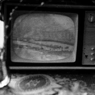 Vintage TV displaying grainy black-and-white image of Jupiter.