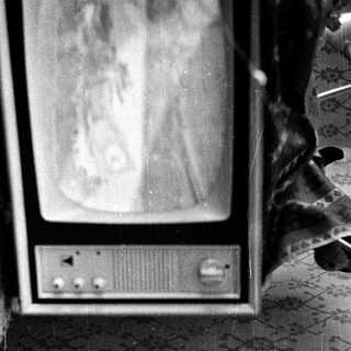 Vintage CRT television on patterned wall.