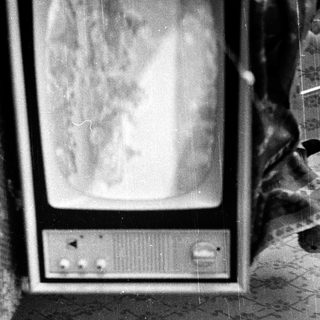 Vintage CRT television on patterned wall.