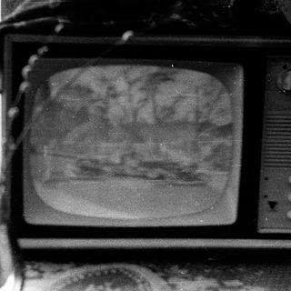 Old CRT television displaying blurred outdoor scene.