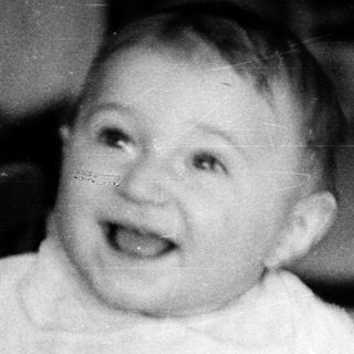 Baby smiling in a crib.