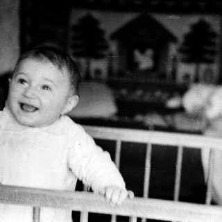 Baby smiling in a crib.