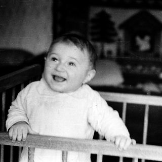 Baby smiling in a crib.