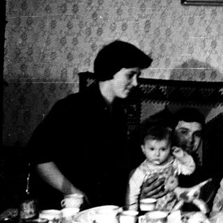 Family gathering in vintage indoor dining setting.