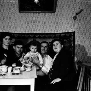 Family gathering around a table indoors.