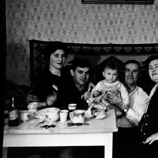 Family gathering around a table indoors.
