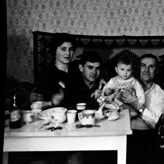 Family gathering around a table indoors.