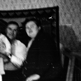 Family group posing indoors around a table.