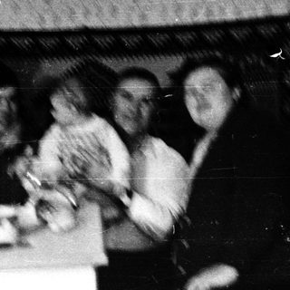 Family group posing indoors around a table.