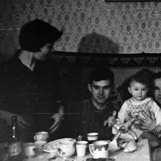 Family gathering indoors during evening meal.