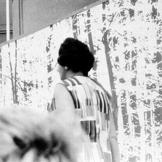 Person examining large abstract mural.