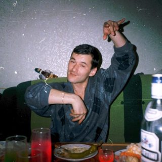 Man raising glass indoors, celebrating with friends.