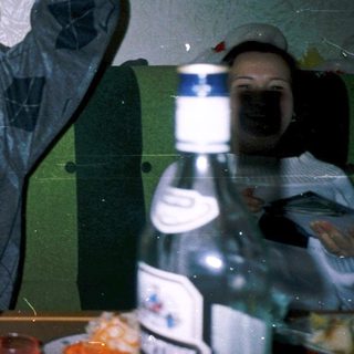 Man raising glass indoors, celebrating with friends.