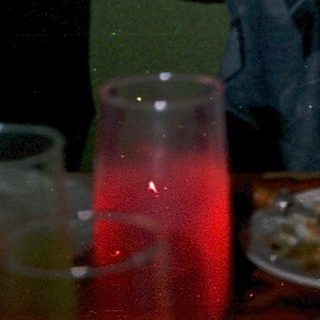 Man raising glass indoors, celebrating with friends.