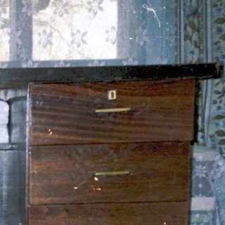 Flooded room with submerged suitcase and belongings.