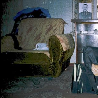Flooded room with submerged suitcase and belongings.