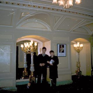 Three men in formal attire posing indoors.