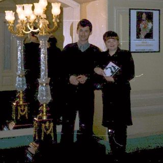 Three men in formal attire posing indoors.