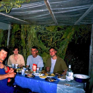 Group enjoying meal together outdoors at night.