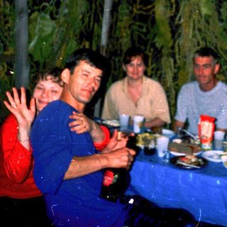 Group enjoying meal together outdoors at night.