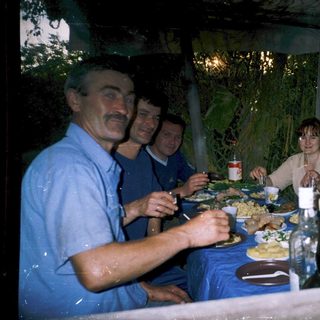 Group enjoying meal together outdoors at night.