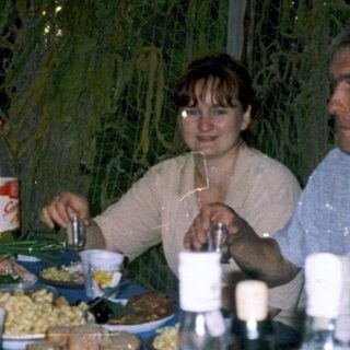 Group enjoying meal together outdoors at night.