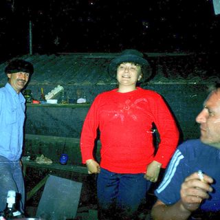 Three people smiling indoors during a casual gathering.