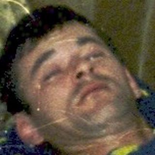Man lying on bed with stuffed toys.