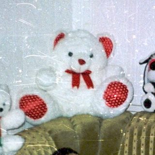 Man lying on bed with stuffed toys.