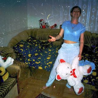 Woman holding stuffed animals in living room.