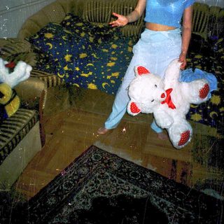 Woman holding stuffed animals in living room.