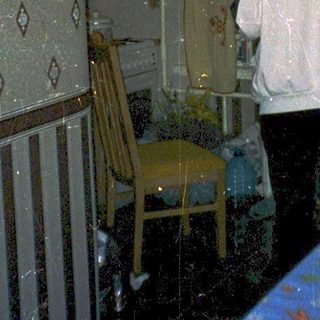 Flooded room with two people standing near table.