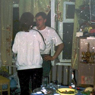 Flooded room with two people standing near table.