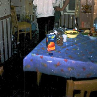 Flooded room with two people standing near table.