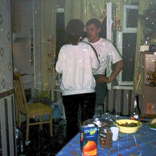 Flooded room with two people standing near table.