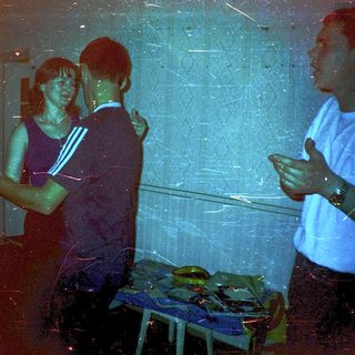 People preparing food in dimly lit kitchen.