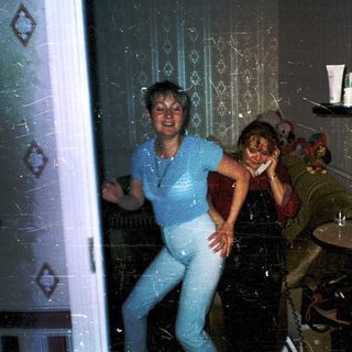 Two women playing motion-based video game indoors.