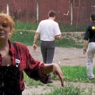 People playing water games outdoors in grassy area.